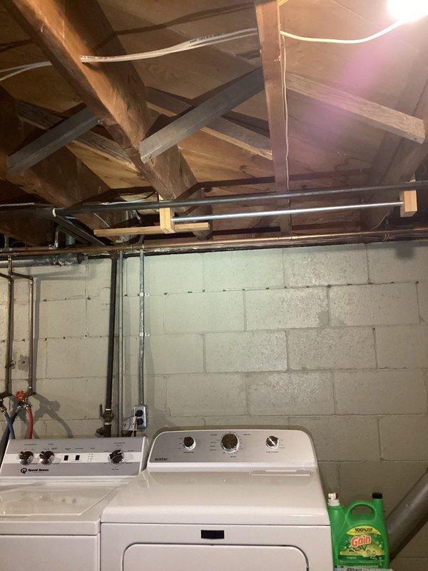 Conducted site evaluation in basement utility area to assess feasibility and routing for gas line installation to three-season room. Inspected existing gas piping infrastructure, structural framework, and available pathways through exposed joists and wall cavities. Documented current plumbing and utility layout including water supply lines, electrical conduit, and HVAC ductwork to determine optimal routing that avoids conflicts with existing systems. Photographed proposed installation area and structural components to prepare accurate estimate for gas line extension with shutoff valve installation.