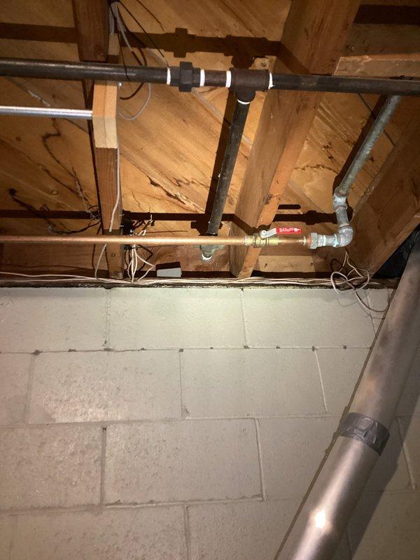 Conducted site evaluation in basement utility area to assess feasibility and routing for gas line installation to three-season room. Inspected existing gas piping infrastructure, structural framework, and available pathways through exposed joists and wall cavities. Documented current plumbing and utility layout including water supply lines, electrical conduit, and HVAC ductwork to determine optimal routing that avoids conflicts with existing systems. Photographed proposed installation area and structural components to prepare accurate estimate for gas line extension with shutoff valve installation.