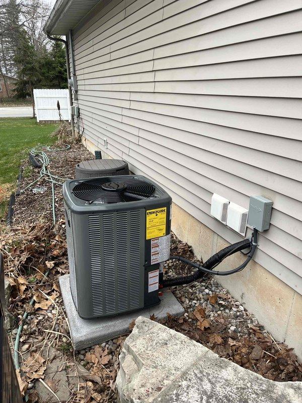 Completed full HVAC system installation including indoor furnace unit and outdoor condensing unit. Installed furnace in basement mechanical room with proper venting using white PVC intake and exhaust pipes, secured copper refrigerant lines with black insulation, and connected condensate drainage with shutoff valves on drain pan. Positioned outdoor condenser unit on concrete pad against foundation, ran electrical conduit to disconnect box, and verified all refrigerant line connections between indoor and outdoor equipment for proper system operation.
