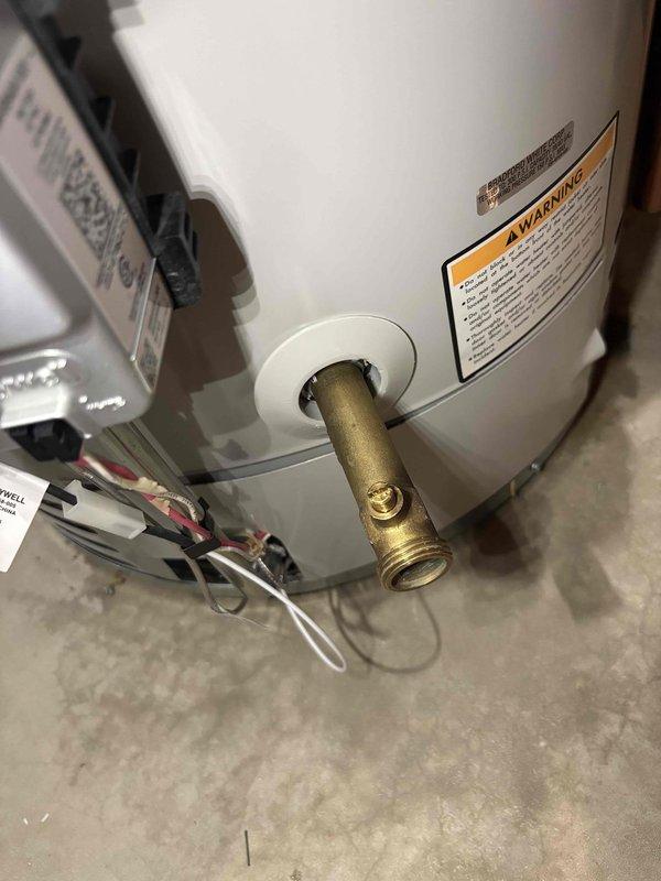 Installed whole home humidifier system with all necessary plumbing connections and fittings. Brass T-fitting and pipe nipple were properly installed and connected to water supply line at water heater location to provide water source for humidifier operation. Installation completed with proper mounting, electrical connections, and water line routing per manufacturer specifications.