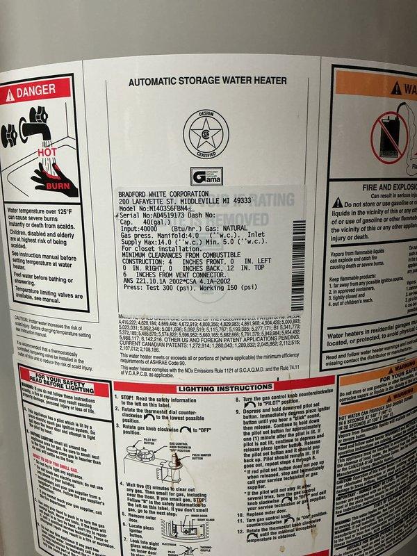 Responded to emergency call for aggressively leaking water heater with complete loss of hot water. Upon arrival, identified Bradford White 40-gallon automatic storage water heater with active leak in basement utility area. Immediately shut off water supply and gas line to unit to prevent further water damage and ensure safety. Documented equipment condition with photographs showing water heater installation, surrounding plumbing connections including copper supply lines with foam insulation, galvanized flue pipe, and proximity to HVAC equipment. Verified unit specifications from manufacturer data plate and assessed overall system configuration in unfinished basement space with exposed joists and concrete flooring.