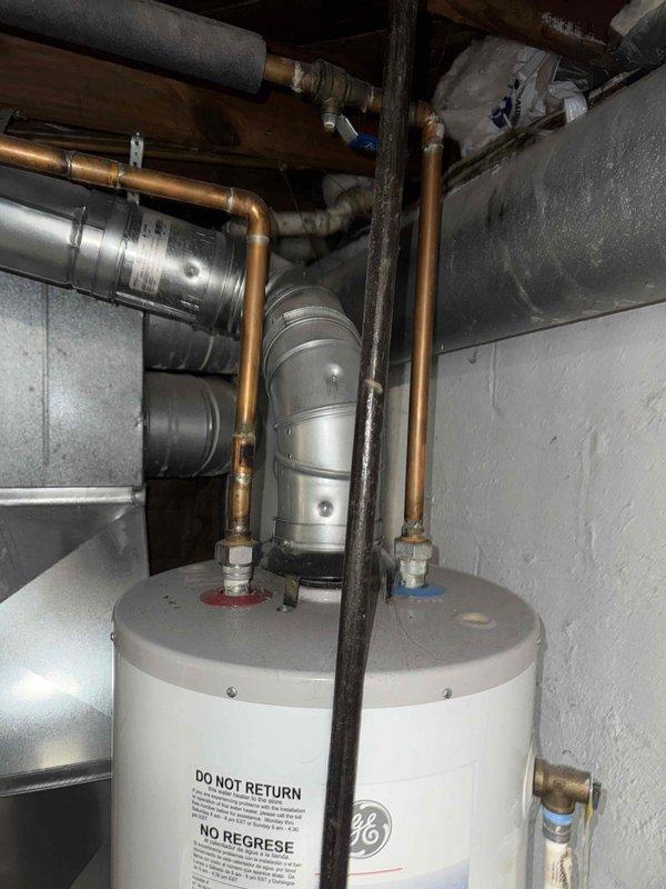 Assessed existing 16-year-old 40-gallon GE water heater installed in 2010 for replacement. Documented current installation including copper supply piping, brass connections, shut-off valves, and venting configuration in basement mechanical room. Provided pricing estimates for complete installation of new 40-gallon and 50-gallon replacement units, as well as labor-only pricing option for customer-supplied equipment.