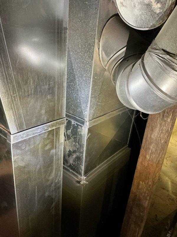 Completed estimate for replacement of 22-year-old residential air conditioning system showing significant age-related wear. Documented existing outdoor condenser unit and attic-mounted ductwork system with visible dust accumulation and surface deterioration, provided replacement options for complete HVAC system upgrade.