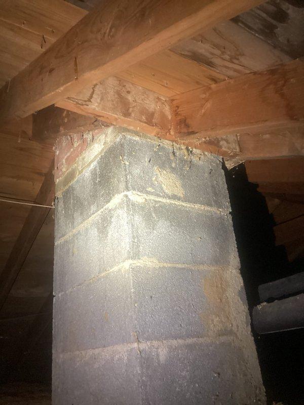 Responded to reported leak around hot water heater in 1951-built residence. Upon inspection, found no active water present at time of visit. Examined water heater cabinet installation including all copper piping, brass fittings, and connections. Inspected vent pipe system extending from water heater through ceiling into attic space. Accessed attic to assess condition of insulated chimney chase and vent termination point. Documented all plumbing connections, shut-off valves, and venting components with photographs for reference. Confirmed proper installation of galvanized vent duct with insulation wrap and structural supports. No visible signs of active leaking observed during inspection period.