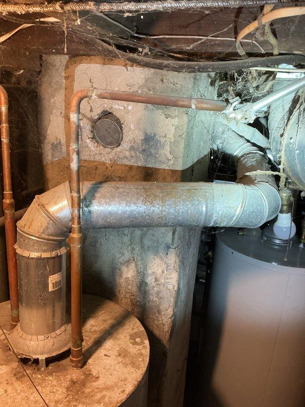 Completed rental inspection for Unit 2, accessing basement mechanical area through lower unoccupied unit using entry code. Performed furnace and water heater inspection, documenting equipment age, brand information, and overall condition. Photographed HVAC system including older heating unit with blue metal cabinet, galvanized ductwork with visible wear and dust accumulation, copper piping, water heater, and associated mechanical components in basement space with exposed joists and insulation.
