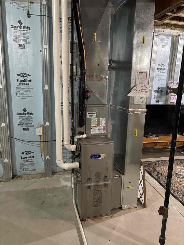 Completed annual heating maintenance inspection on Carrier furnace system in basement mechanical room. Performed comprehensive tune-up including visual inspection of unit, ductwork connections, and venting system. Verified proper operation of all furnace components, checked burner assembly, inspected heat exchanger, and confirmed adequate airflow through supply ductwork. Examined PVC condensate drainage lines for proper pitch and functionality. Documented system condition with photographs showing clean installation with organized piping and ductwork routing. All safety controls tested and operating within manufacturer specifications. Unit found in good working order with no immediate service needs identified.