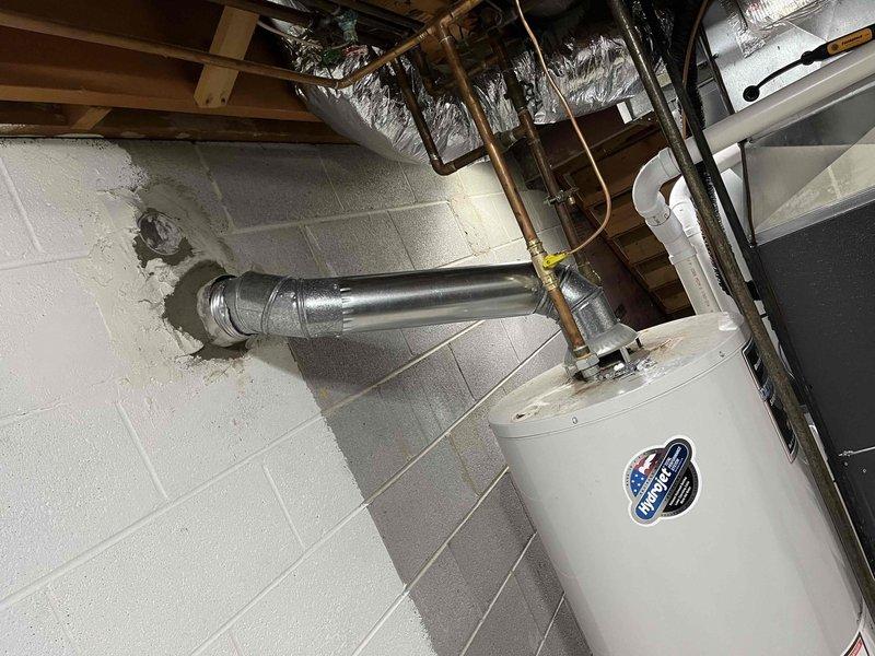 Completed full installation of new furnace and air conditioning system. Interior furnace unit installed in basement utility area with proper ductwork connections to existing galvanized metal distribution system and appropriate clearances from water heater and building infrastructure. Exterior condensing unit positioned on concrete pad with refrigerant line sets and electrical disconnect properly installed per manufacturer specifications.