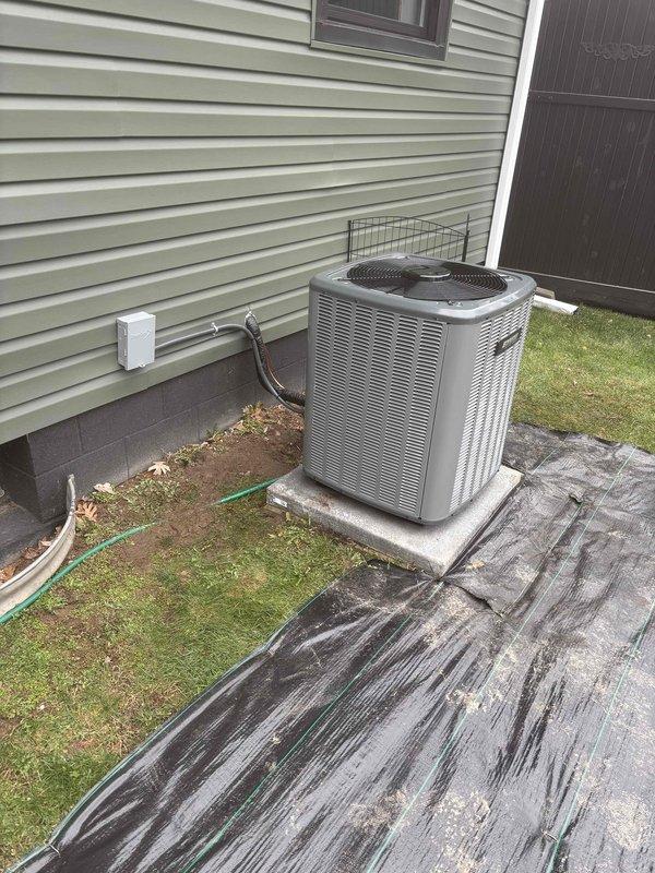 Completed full installation of new furnace and air conditioning system. Interior furnace unit installed in basement utility area with proper ductwork connections to existing galvanized metal distribution system and appropriate clearances from water heater and building infrastructure. Exterior condensing unit positioned on concrete pad with refrigerant line sets and electrical disconnect properly installed per manufacturer specifications.