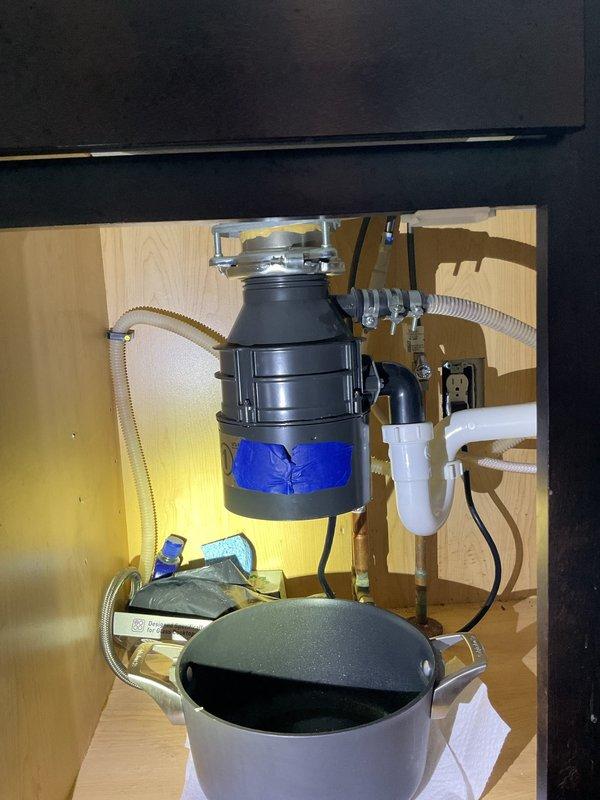 Responded to garbage disposal leaking from bottom. Upon inspection, identified leak originating from disposal unit's lower housing seal. Removed and replaced defective garbage disposal with new unit, reconnected drain lines and dishwasher discharge hose, tested system for proper operation and verified no leaks present.