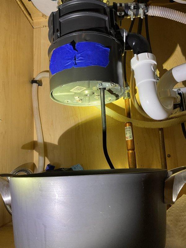 Responded to garbage disposal leaking from bottom. Upon inspection, identified leak originating from disposal unit's lower housing seal. Removed and replaced defective garbage disposal with new unit, reconnected drain lines and dishwasher discharge hose, tested system for proper operation and verified no leaks present.