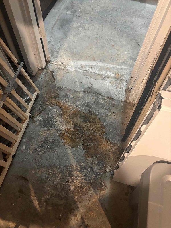 Responded to water leak complaint near furnace following recent AC installation. Upon arrival, inspected the area and discovered significant water staining and moisture accumulation on concrete floor surrounding the HVAC equipment. Traced the source of the leak to condensate drainage issue related to the newly installed air conditioning system. Examined the evaporator coil assembly, drain pan, and condensate line connections. Found that the condensate drain line was not properly secured and draining correctly, causing water to overflow onto the floor. Repositioned and secured the condensate line, verified proper pitch for drainage, and tested the system operation. Confirmed condensate was flowing properly through the drain line without leakage. Cleaned up accessible water residue and advised that existing concrete staining would require time to dry completely. System tested and operating within normal parameters with no further leakage observed.