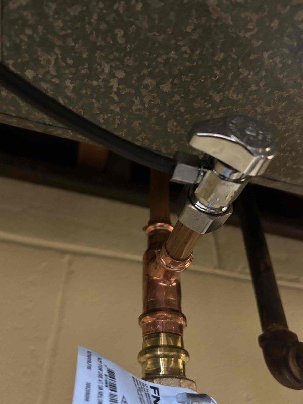# Plumbing Leak Repair

Responded to a plumbing leak issue and performed comprehensive inspection of water supply lines and shut-off valve assembly. Located active leak at copper pipe compression fitting connection beneath sink fixture. Tightened compression fittings on copper supply line and replaced faulty angle stop valve with new chrome-finished shut-off valve to eliminate leak. Verified all connections were secure and tested system under full water pressure to confirm leak was resolved. Inspected adjacent black supply lines and electrical conduit for any secondary issues. Applied proper torque to all fittings and ensured no water seepage at valve connections. System restored to full operational status with no active leaks detected upon completion.