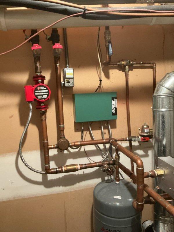 Completed annual cooling system maintenance on 13-year-old EnergiAir unit with condenser model year 2020. Performed standard tune-up procedures including system inspection, operational testing, and documentation with photos of hydronic heating system and associated mechanical components in basement utility area.