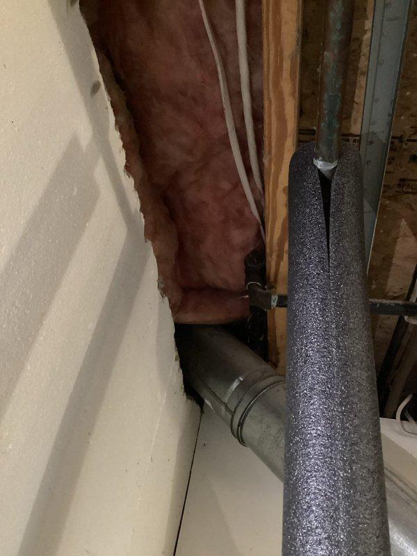 Completed comprehensive assessment for full-home conversion from liquid propane to natural gas in preparation for new utility gas line installation at 30-year-old residential property. Evaluated existing LP appliances, gas piping infrastructure, and venting systems throughout home. Documented current gas regulator location behind exterior access panel and photographed basement utility area showing exposed framing, insulation, and existing ductwork routing to determine optimal natural gas line pathways and conversion requirements for all gas-burning equipment.