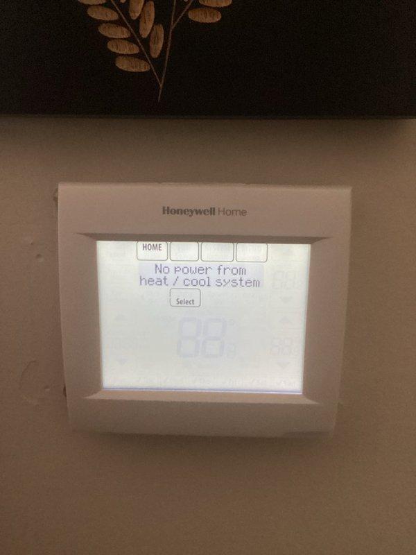 Responded to no power alert at thermostat for 12-year-old Trane system. Upon arrival, confirmed Honeywell thermostat displaying "No power from heat/cool system" error message. Inspected HVAC unit and identified significant rust staining along interior base panel seam, indicating previous moisture intrusion. Checked electrical connections, control board, and low-voltage wiring at unit. Restored power to system and verified thermostat communication. Performed requested tune-up maintenance including inspection of all accessible components.