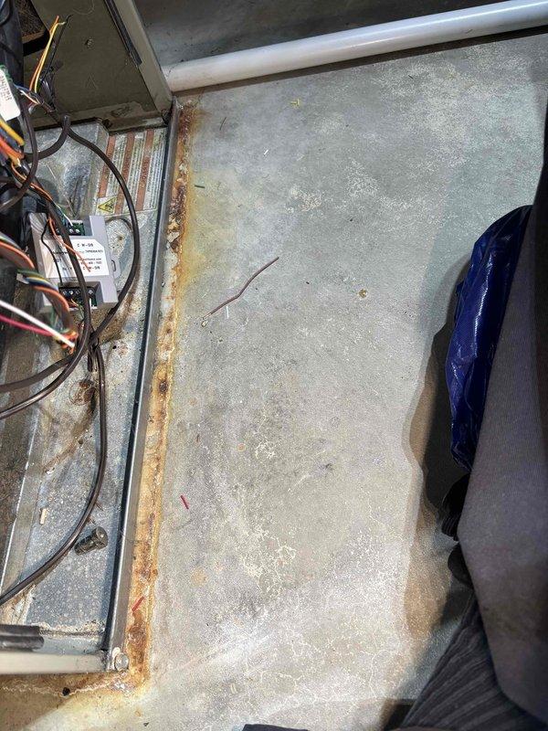 Responded to no power alert at thermostat for 12-year-old Trane system. Upon arrival, confirmed Honeywell thermostat displaying "No power from heat/cool system" error message. Inspected HVAC unit and identified significant rust staining along interior base panel seam, indicating previous moisture intrusion. Checked electrical connections, control board, and low-voltage wiring at unit. Restored power to system and verified thermostat communication. Performed requested tune-up maintenance including inspection of all accessible components.