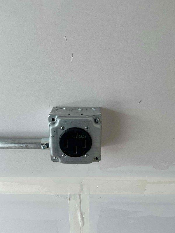 # Electrical Receptacle Installation

Installed new electrical receptacle in garage area per customer request. Ran metal conduit along wall from existing junction box to new receptacle location. Mounted weatherproof junction box on ceiling to house electrical connections. Secured conduit with appropriate clips and brackets to wall surface. Installed receptacle in newly constructed drywall area. All work completed in accordance with current NEC standards. System tested and verified operational upon completion.