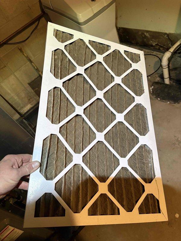 Completed annual cooling maintenance on 14-year-old Trane system. Inspected and documented condition of air filter showing significant dust and debris accumulation in pleated media; checked indoor air handler components revealing contamination on evaporator coil and surrounding surfaces with visible moisture staining on metal housing. Photographed equipment condition for service records.