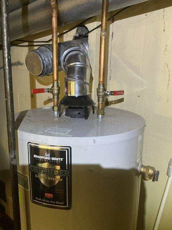 Responded to no hot water call and performed diagnostic evaluation on 5-year-old Bradford White water heater with warranty expiration in July 2026. Upon inspection, unit appeared properly installed with standard copper supply lines, red-handled shut-off valves, and appropriate safety connections. Documented current installation configuration and water heater condition with photographic evidence for service records.