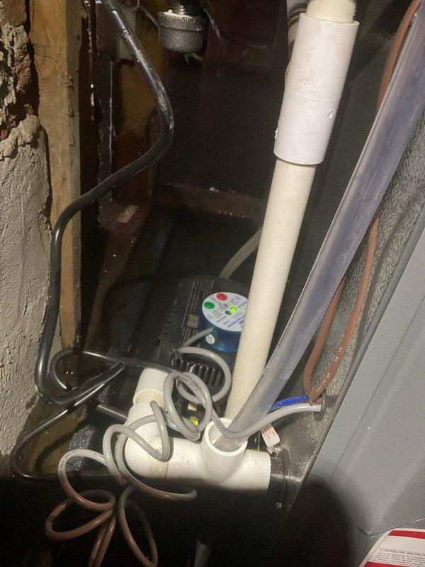 # No Heat Service Call

Responded to no heat call with alarm sounding at furnace. Upon arrival, found significant water pooling on basement floor around HVAC equipment and water heater. Investigation revealed condensate drain system failure, causing water backup that triggered the furnace safety float switch and alarm.

Located malfunctioning condensate pump assembly with electronic control unit at base of PVC drain line. Pump had failed to evacuate condensate water, resulting in overflow condition throughout mechanical space. Water accumulation activated furnace safety lockout to prevent equipment damage.

Cleared water from affected area and removed failed condensate pump. Installed new condensate pump assembly with safety switch. Reconnected PVC drain lines and verified proper discharge operation. Tested pump cycling under load to ensure adequate flow rate and proper float switch function.

Reset furnace control board and cleared alarm code. Verified all safety interlocks functionin