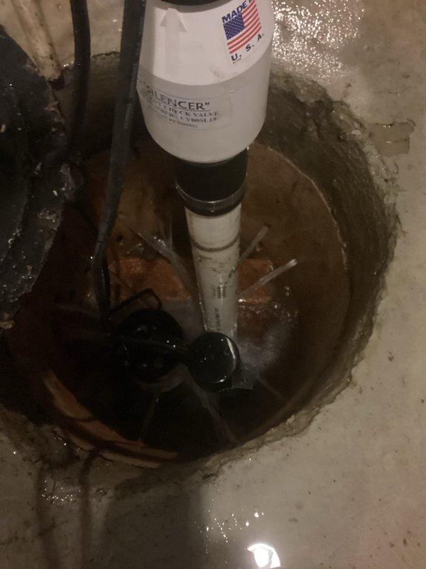 Responded to sump pump failure causing significant water accumulation in basement. Upon arrival, found extensive standing water throughout the concrete floor with multiple areas of pooling. Inspected existing sump pump system and found the pump operational but inadequate for current water intrusion levels. Assessed basin for proper depth and drainage, noting sediment and rust accumulation in standing water. Deployed emergency water extraction equipment using portable pumps and hoses to remove immediate flooding from basement floor. Cleared debris from sump basin and verified discharge line functionality. Recommended ongoing monitoring of water table levels and potential upgrade to higher capacity pump system to prevent future basement flooding events.