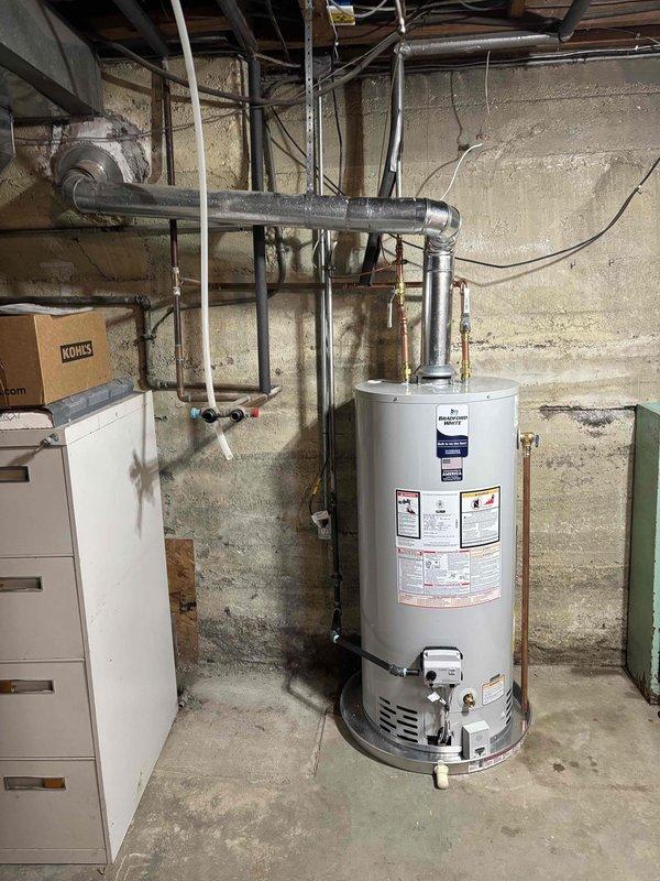 Completed installation of a Bradford White 40-gallon natural gas water heater, model RG240S6N, rated at 40,000 BTU/hr. Connected all copper supply and discharge piping with proper shut-off valves and pressure relief components. Installed unit in basement utility area against foundation wall with adequate clearance per manufacturer specifications. Verified proper gas manifold pressure settings and natural draft venting requirements per ANSI compliance standards. All connections insulated and secured, unit tested and operational.