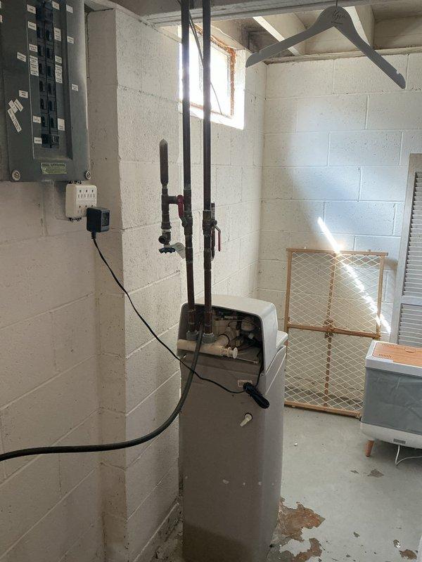 Responded to service call for water softener continuously filling with water in 1960s-era home. Upon arrival, accessed basement through unlocked front door per customer instructions. Located unit beneath electrical panel on back wall as directed. Conducted diagnostic inspection of water softener system, checking float assembly, brine tank water level, control valve operation, and inlet water flow. Photographed equipment and surrounding area for documentation purposes. Identified malfunction causing improper fill cycle that had persisted for 2-3 weeks. Performed necessary repairs to restore proper water softener operation and prevent continued overfilling condition.