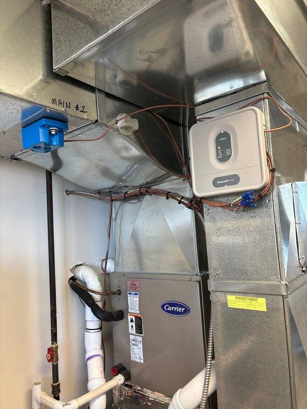 Completed full furnace installation at residential property, replacing existing heating system with new Carrier brand unit. Installation included mounting and securing furnace unit, connecting all necessary ductwork and sheet metal plenum, routing copper refrigerant lines, installing white PVC condensate drainage piping with proper fittings and valves, running electrical conduit and wiring, and positioning condensate drain pan at equipment base. All components properly mounted, sealed, and tested for operational functionality per manufacturer specifications.