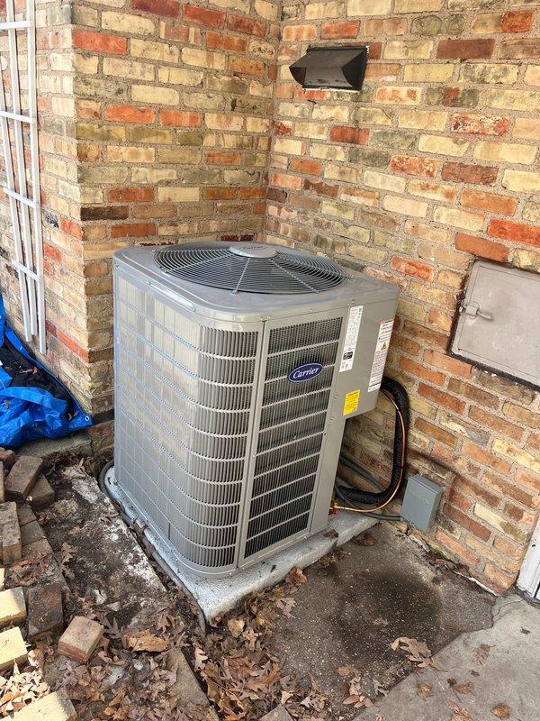 Completed full HVAC system replacement including installation of new Carrier brand furnace and air conditioning condenser unit. Furnace installed in basement/utility room on proper platform with new PVC venting and drainage piping, electrical conduit, and gas line connections. AC condenser unit positioned on concrete pad in exterior corner alcove, secured with proper electrical disconnect panel and refrigerant line connections. All components tested and operational upon completion.