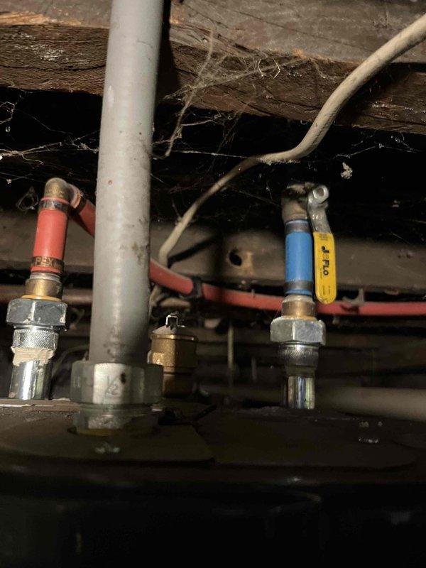Responded to service call for no hot water condition. Inspected water heater installation in crawl space and verified proper operation of inlet/outlet isolation valves with red and blue handles. Confirmed water supply connections and plumbing infrastructure were intact with no visible leaks or damage to flexible supply lines or surrounding pipe work.