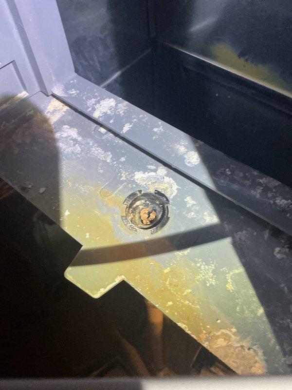 Responded to water leak from furnace unit. Upon inspection, found heavily clogged air filter restricting airflow and causing condensation issues, along with significant debris and mineral buildup in the drain pan with discoloration around the drain opening. Documented conditions with photos showing the contaminated drain pan and severely soiled filter. Addressed the immediate water leak concern while unit remained operational.
