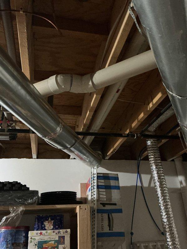 Conducted site assessment for water heater replacement in residential property. Evaluated existing installation location in utility area with exposed ceiling joists, documented current plumbing configuration including white PVC venting system and existing ductwork routing, and provided comprehensive estimates for both traditional tank-style and tankless water heater options to customer for consideration.