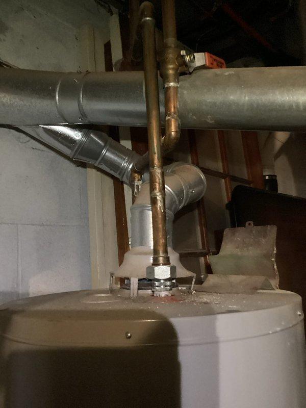 Responded to water heater leak on 12-15 year old A.O. Smith unit. Upon inspection, observed water staining and discoloration on concrete floor surrounding base of water heater, confirming active leak. Documented existing plumbing configuration including copper supply lines, brass fittings, temperature and pressure relief valve, and connection points. Photographed unit and surrounding area showing leak evidence and overall system condition. Given age of unit and active leak, provided assessment and recommendations for repair or replacement options.