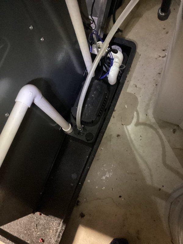 Completed annual cooling maintenance and system inspection on residential HVAC unit. Inspected condensate pump assembly and drainage system in mechanical room, verified proper operation of pump mechanism and PVC drain lines, confirmed adequate water discharge with no blockages present. Documented existing moisture staining on floor surface consistent with normal condensate drainage activity. All components functioning within normal parameters, system ready for cooling season operation.