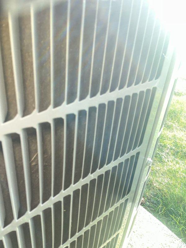 Completed annual cooling maintenance on Carrier air conditioning system. Performed comprehensive tune-up inspection of outdoor condenser unit, which was found to be in good operating condition with clean coils and proper airflow through the heat exchanger fins. Verified condenser unit is level on concrete pad with adequate clearance and maintained surroundings. Inspected protective grille and cabinet housing, noting normal weathering with no structural damage or deterioration. Examined heat exchanger coils and fins, confirming proper condition and heat transfer capability. Unit shows signs of regular maintenance with no immediate service concerns identified. System operational and ready for cooling season.