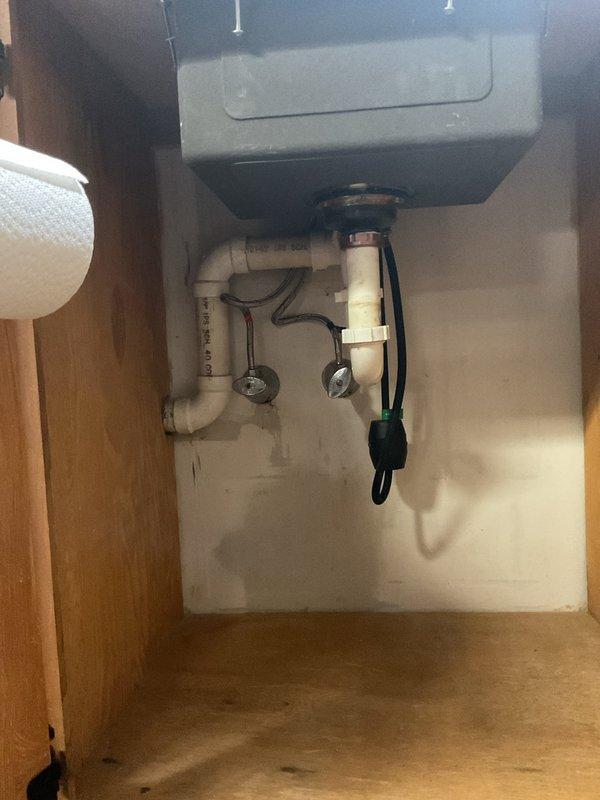 Reworked lavatory sink drain system and installed Air Admittance Valve (AAV) to resolve drainage issues. Reconfigured existing white PVC P-trap assembly under sink, ensuring proper trap seal and drainage flow. Installed AAV to provide necessary venting where conventional vent stack was not accessible. Verified all connections are secure, leak-free, and meet code requirements for proper drain-waste-vent function.
