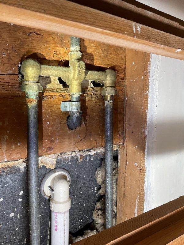 Responded to leaking tub faucet that continued to drip after homeowner attempted washer replacement. Upon inspection, accessed plumbing assembly behind wall and identified worn valve seat and corroded brass valve body as root cause of persistent leak. Replaced faulty valve assembly and tested system to confirm proper water flow and complete elimination of leak.