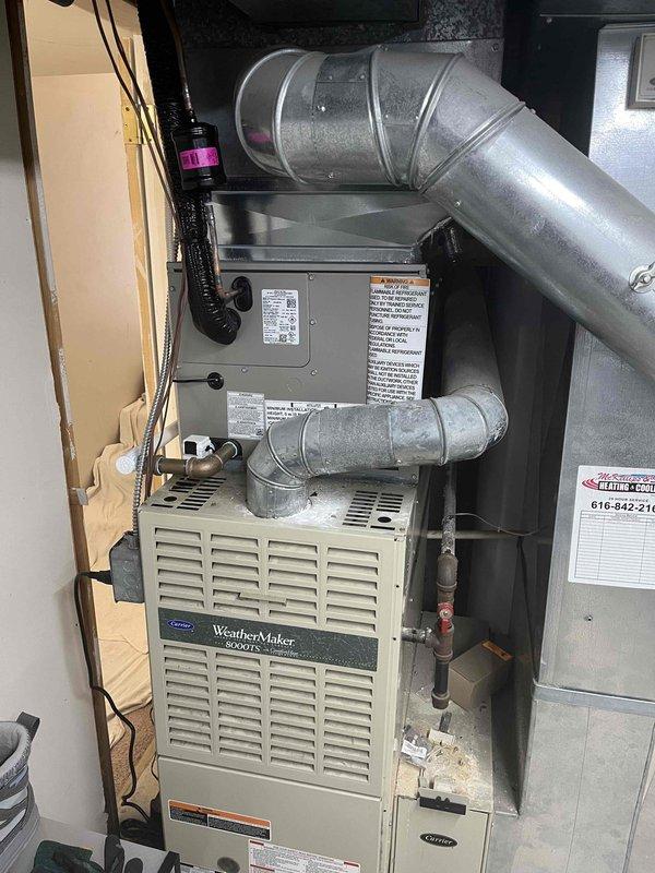 Successfully completed full HVAC system installation including new Carrier air conditioning condenser unit positioned on concrete pad with proper clearances from building exterior and ventilation louvers. Indoor installation included WeatherMaker 8000TS furnace with integrated air handler, complete ductwork connections utilizing galvanized metal supply ducts with properly sealed joints and elbows. All refrigerant lines, electrical conduit, and condensate drainage installed per manufacturer specifications. System tested and verified operational, with all safety labels and equipment documentation properly affixed.