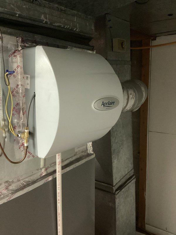 Completed annual cooling maintenance on two one-year-old air conditioning systems. Performed comprehensive inspection of both units including filter replacement, coil cleaning, refrigerant level verification, electrical connection testing, and condensate drain line flushing. Inspected basement-mounted Aprilaire humidifier unit with associated ductwork and plumbing connections, confirming proper operation and secure mounting. Accessed attic space to inspect main supply ductwork labeled "Main #1 Back," verified all duct connections are sealed and insulation is intact. Both AC systems operating within manufacturer specifications with no deficiencies noted. All components tested and confirmed functional for the cooling season.