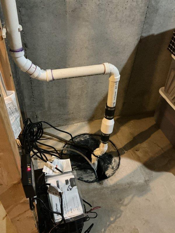 Replaced battery backup sump pump and sewage ejector pump system in basement utility area. Installed new pumps with associated PVC discharge piping, electrical connections, and basin components to restore proper water management and sewage handling functionality.