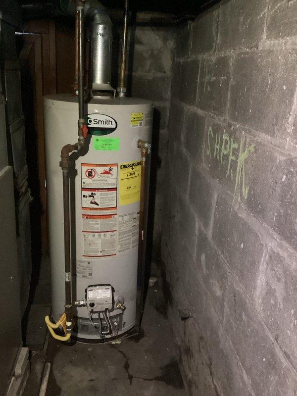 Responded to water heater failure following basement flooding incident. Upon arrival, inspected 15-year-old A.O. Smith water heater unit for water damage and operational status. Evaluated electrical connections, gas supply lines, copper piping, shut-off valves, and flue venting system for flood-related damage or debris. Assessed pilot light, thermocouple, and burner assembly functionality. Documented equipment condition with photographs showing water heater installation, surrounding utility area, and associated plumbing connections. Verified proper venting and clearances around unit. Customer advised of findings and unit restored to working order.