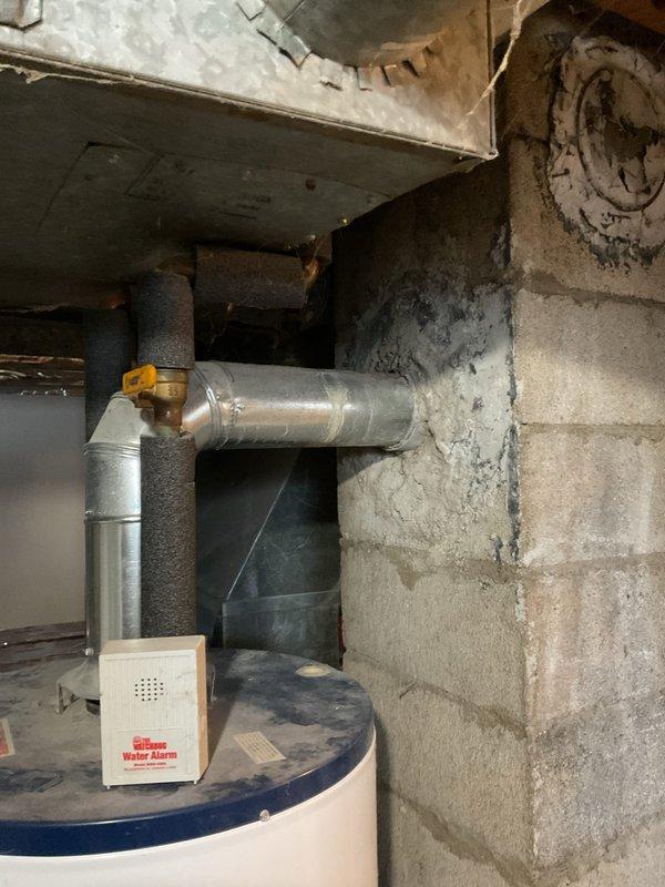 Conducted on-site assessment of leaking residential water heater in basement utility area. Evaluated existing unit, documented current installation conditions including water alarm system, ductwork proximity, and access clearances, and provided estimate for replacement with 40-gallon water heater to resolve active leak condition.