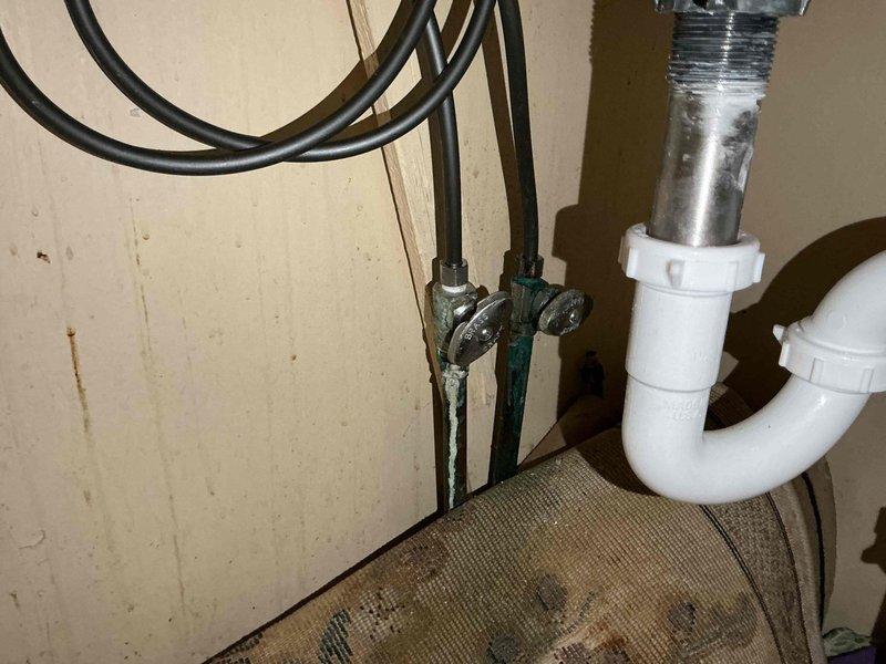 Responded to service call for bathroom faucet experiencing intermittent dripping for approximately one year in a fifty-year-old residential property. Upon inspection, identified worn internal valve components and corroded supply line connections beneath the sink as the primary causes of the leak. Disassembled faucet assembly, replaced deteriorated cartridge and seals, and addressed corroded metal fittings showing greenish-blue oxidation. Verified proper operation of single-handle chrome faucet and pop-up drain assembly. Tested water flow and confirmed complete elimination of dripping issue. System restored to full functionality with no leaks detected at completion.