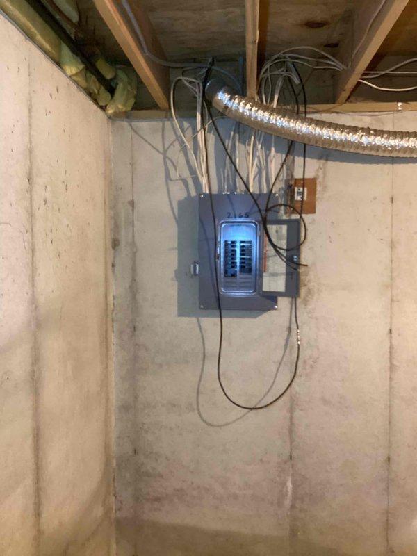 Conducted on-site evaluation for Kohler generator installation. Assessed existing electrical infrastructure in basement utility area, documenting current electrical panel configuration, available space for equipment placement, and necessary connection points. Photographed electrical service panel with exposed circuit breakers and existing wiring pathways to determine compatibility with automatic transfer switch requirements and generator integration needs.