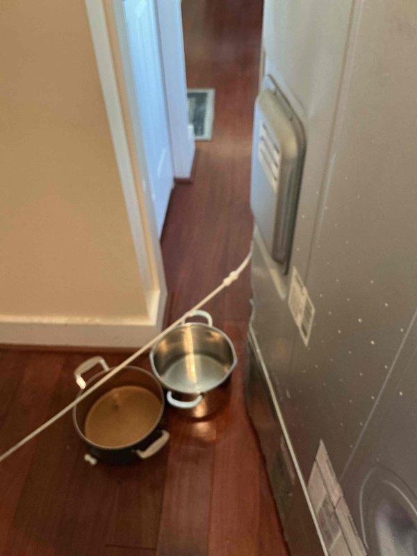 Responded to emergency plumbing leak in basement with water accumulation at approximately half gallon per hour. Upon arrival, found active leak with collection pots positioned on hardwood flooring to catch water. Investigated suspected refrigerator water line as source of leak. Identified and isolated leak source, performed necessary repairs to stop water flow. No dedicated shutoff valve was present at the fixture, requiring main water supply manipulation to complete repairs safely.