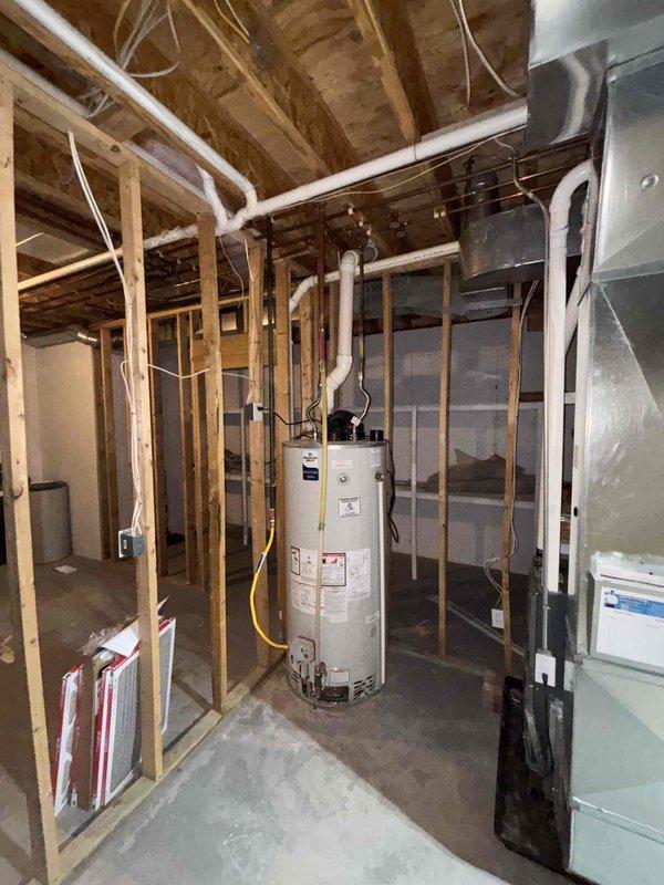 Responded to complaint of extended hot water delivery time (10-15 minutes) and low water pressure throughout residence. Inspected water heater, pressure tank, and associated plumbing system in basement utility area. Diagnosed issue with pressure tank system affecting both hot water circulation and overall water pressure. Tested pressure switch settings, checked tank pre-charge pressure, and verified water heater operation. Adjusted pressure tank settings and system controls to restore proper water pressure and reduce hot water wait time. Verified improvements to water flow and temperature delivery at multiple fixtures throughout the home.