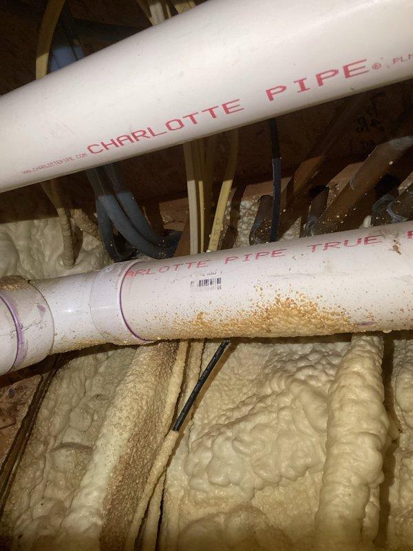 Responded to plumbing leak emergency where water supply had been shut off due to active leak. Upon inspection, identified leak in Charlotte Pipe FlowGuard CPVC water supply line running through exposed ceiling/attic space near spray foam insulation and wooden joists. Performed pipe repair to damaged section of water line showing discoloration and failure point. Restored water supply and verified system integrity with no additional leaks detected. Also inspected aging copper piping in basement area near water heater to ensure no secondary leak sources were present.