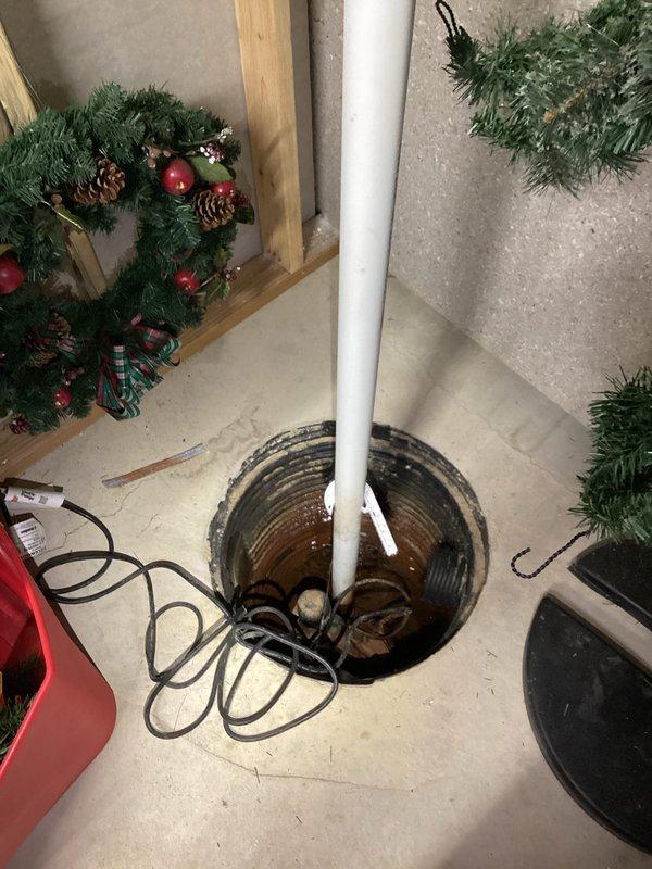 Conducted on-site assessment for secondary sump pump installation in basement utility area. Evaluated existing sump pit with corrugated metal walls and standing water, documented current PVC discharge piping configuration, and identified optimal placement for backup pump system to provide redundant water removal capability during primary pump failure or power outage scenarios.