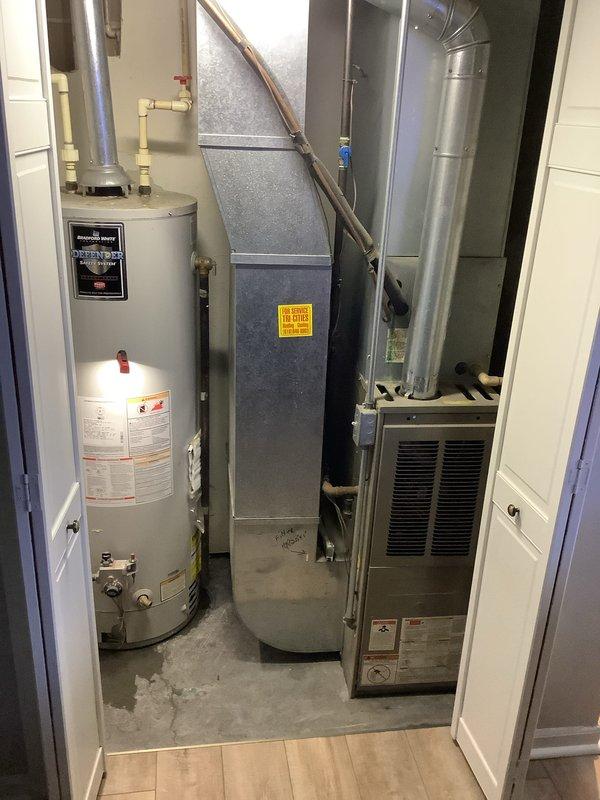 Provided estimate for replacement of 19-year-old Bradford White water heater located in mechanical room alongside existing HVAC equipment. Documented current installation including copper piping connections, brass fittings, and control valves at base of unit for customer review and replacement planning.