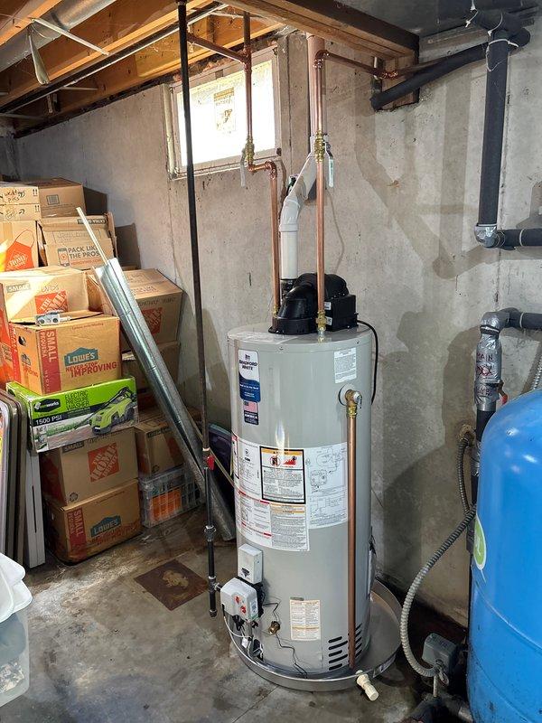 Installed a Bradford White 40-gallon automatic storage water heater with 60,000 BTU/h capacity in basement utility area. Connected copper supply lines with brass fittings to unit inlet/outlet, installed black expansion tank on vertical piping, and established proper clearances to combustibles per manufacturer specifications. Verified all gas connections, tested unit operation, and confirmed proper venting and safety controls were functioning correctly.